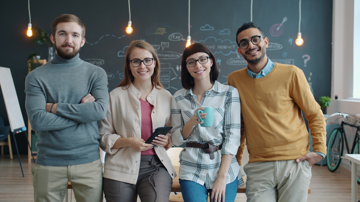 A diverse team of smiling professionals standing together in a modern office